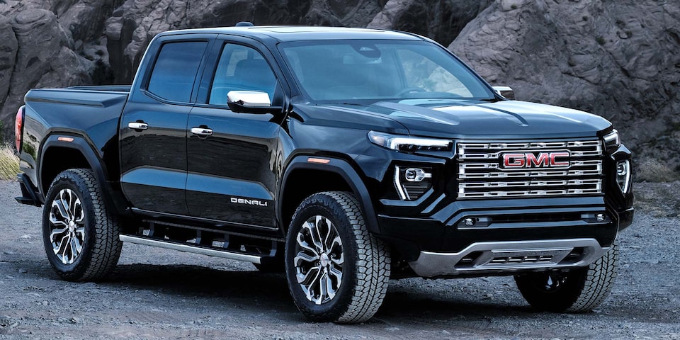 Vue latérale avant du GMC Canyon Denali 2025 en mouvement devant une falaise.