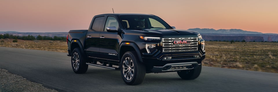 2025 GMC Canyon Denali driving down the road during sunset.
