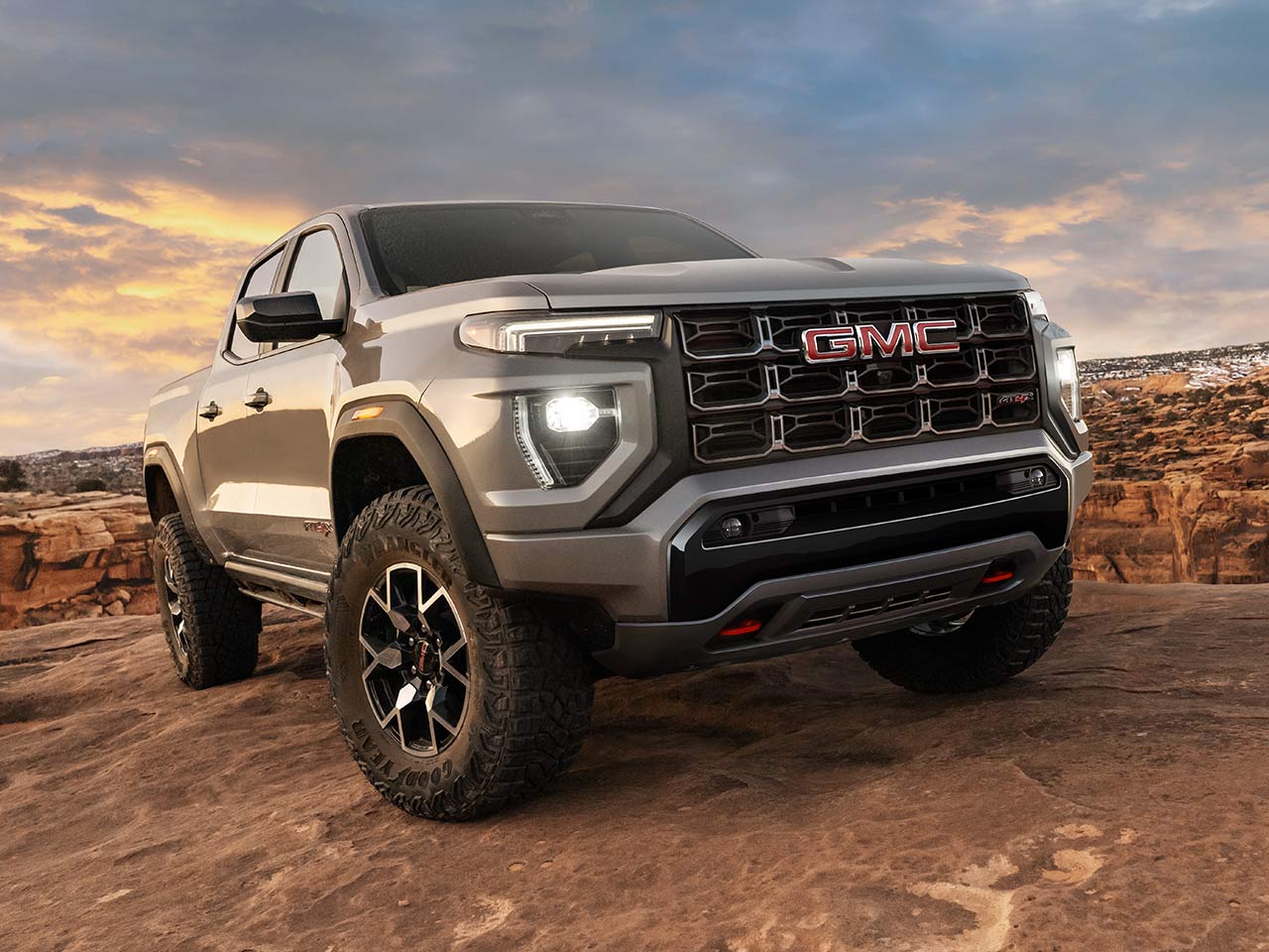 Le GMC Canyon AT4 2026 en mouvement seul dans un milieu rocailleux.