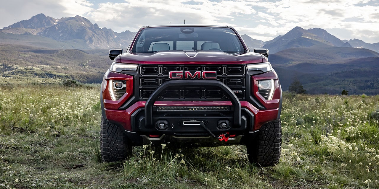 Vue avant du GMC Canyon AT4 2026 stationné dans un pré par une journée ensoleillée.