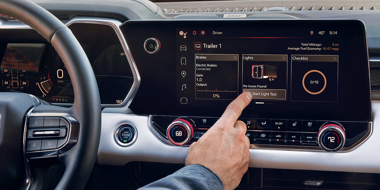 Une personne accède à un menu sur l’écran du système d’infodivertissement du GMC Canyon AT4 2026.