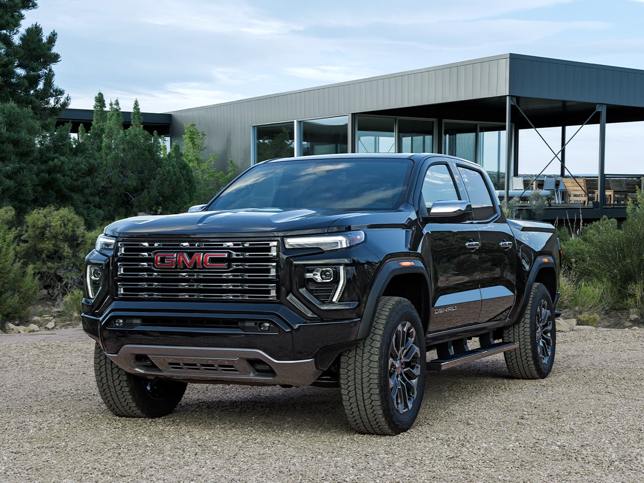 Le GMC Canyon Denali 2026 stationné devant une maison moderne.