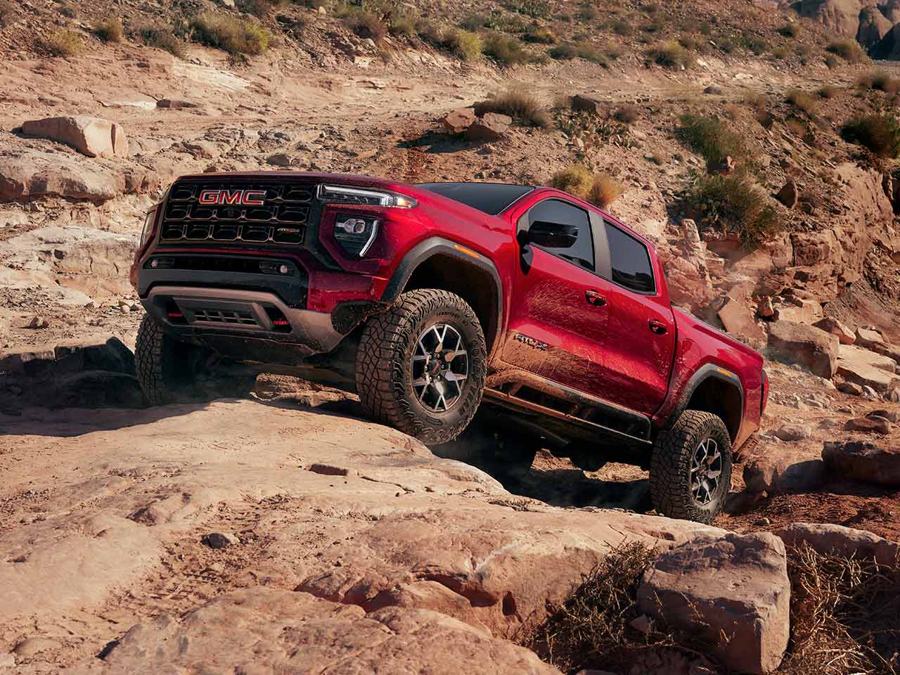 Front-side view of the 2026 GMC Canyon parked on a rocky terrain.