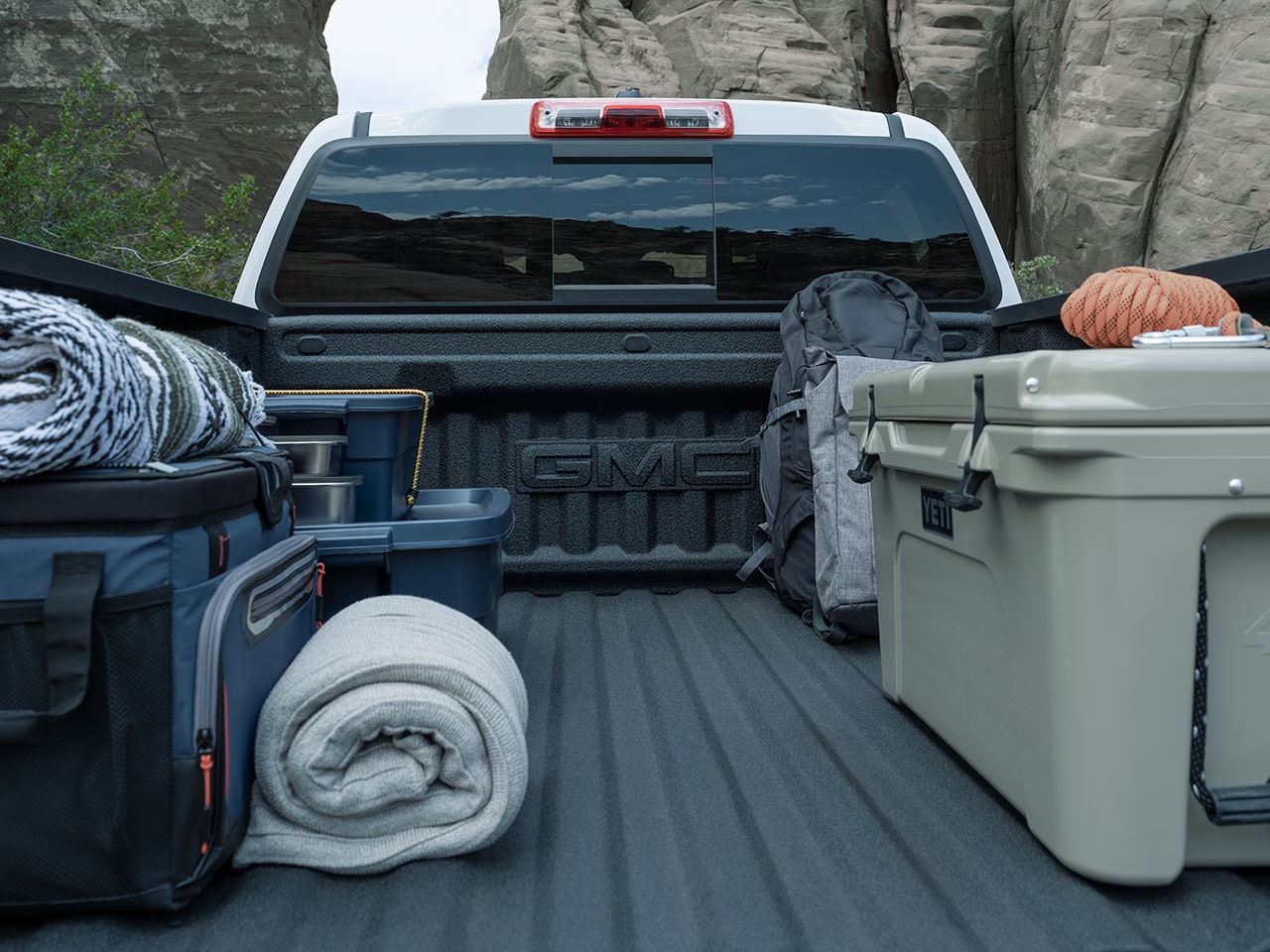 Bags and crates stowed on the Cargo Bed of the 2026 GMC Canyon.