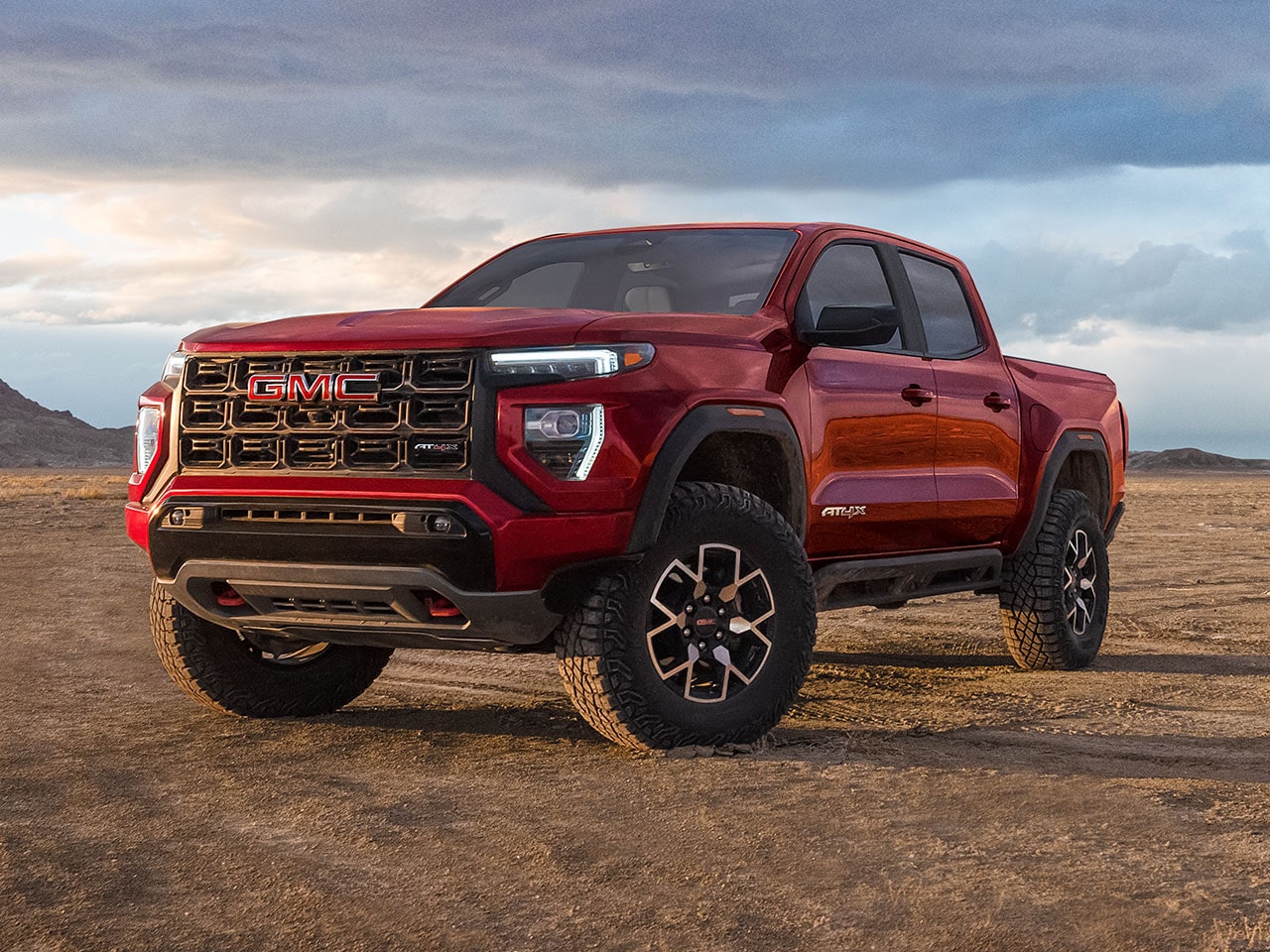 Front-side view of the 2026 GMC Canyon parked alone on a desert terrain.