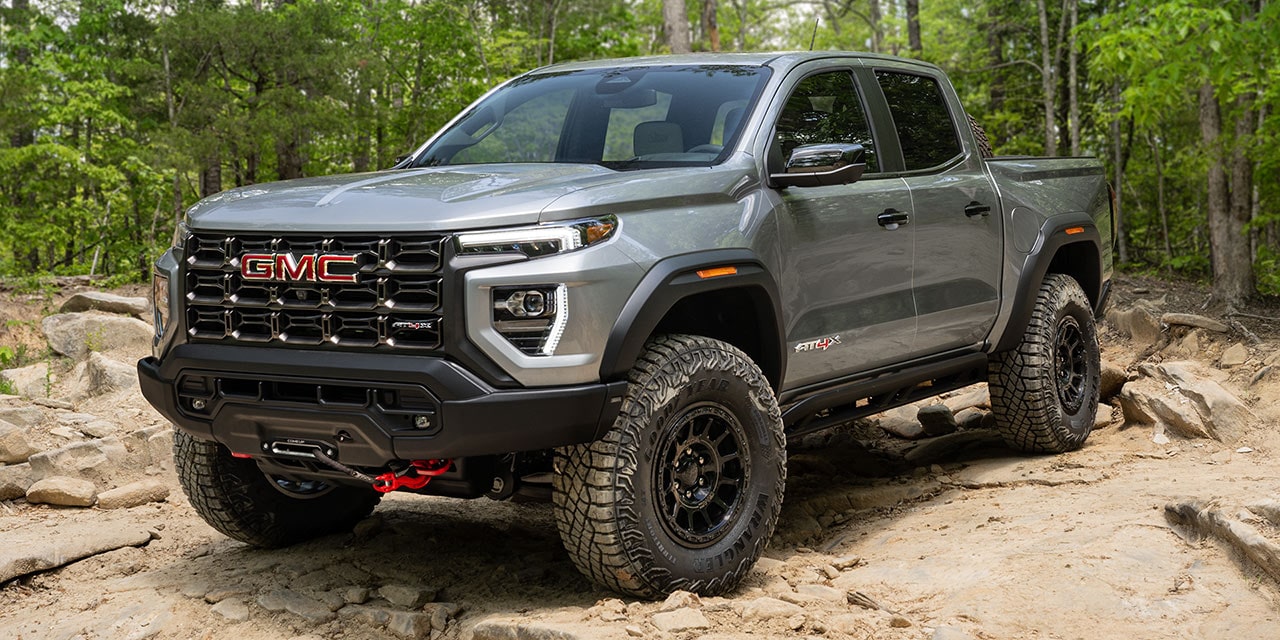 Front-side view of the 2026 GMC Canyon AT4X parked in a forest setting.