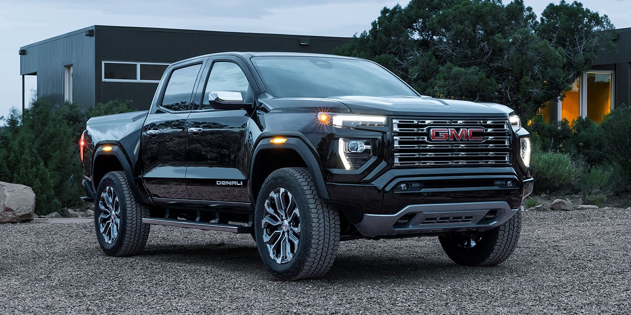 Front-side view of the 2026 GMC Canyon parked on a pebbled terrain.