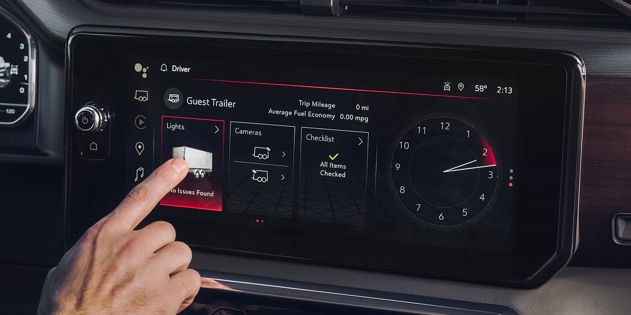 Close-up of a Driver Using the In-Vehicle Trailering App on the Infotainment Screen of the 2026 Sierra 1500 AT4.