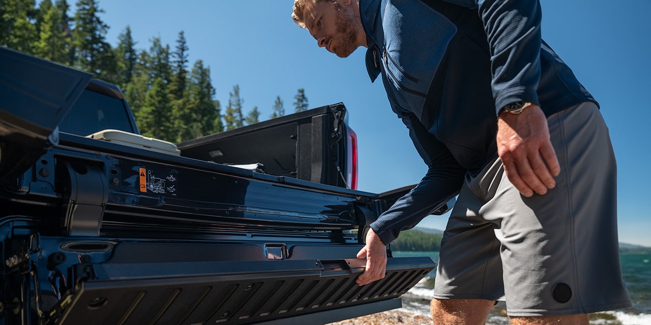 A Person utilizing the Multipro Tailgate on his 2026 GMC Sierra 1500 Pickup Truck.