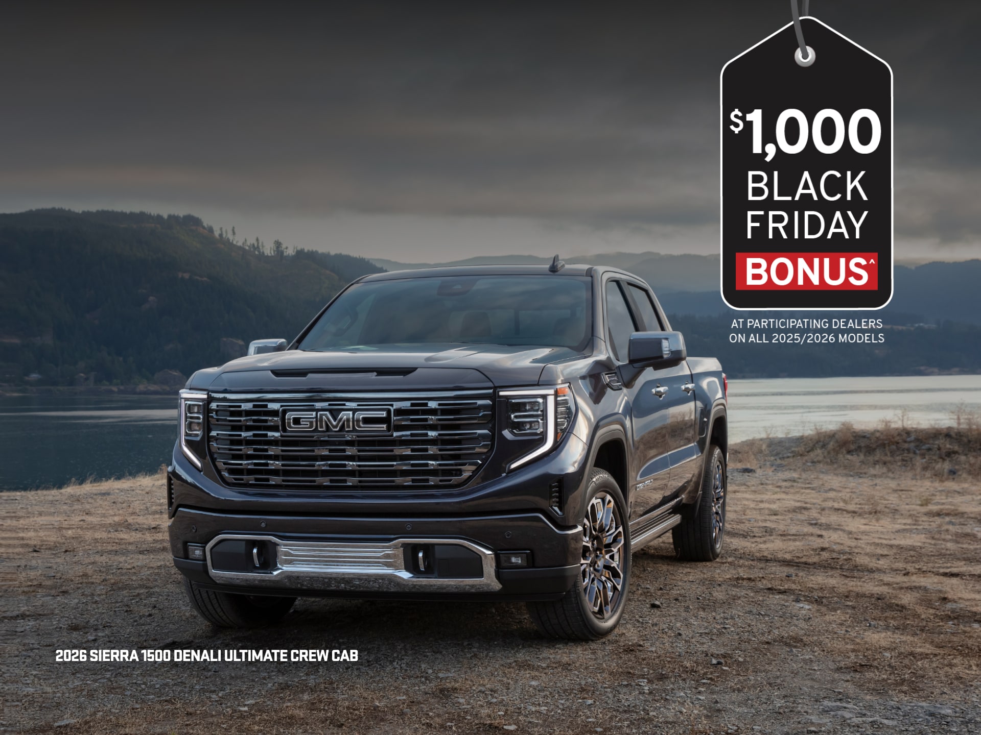 Two 2026 GMC Sierra 1500 Pickup Trucks Parked in a Grassy Field by a Body of Water.