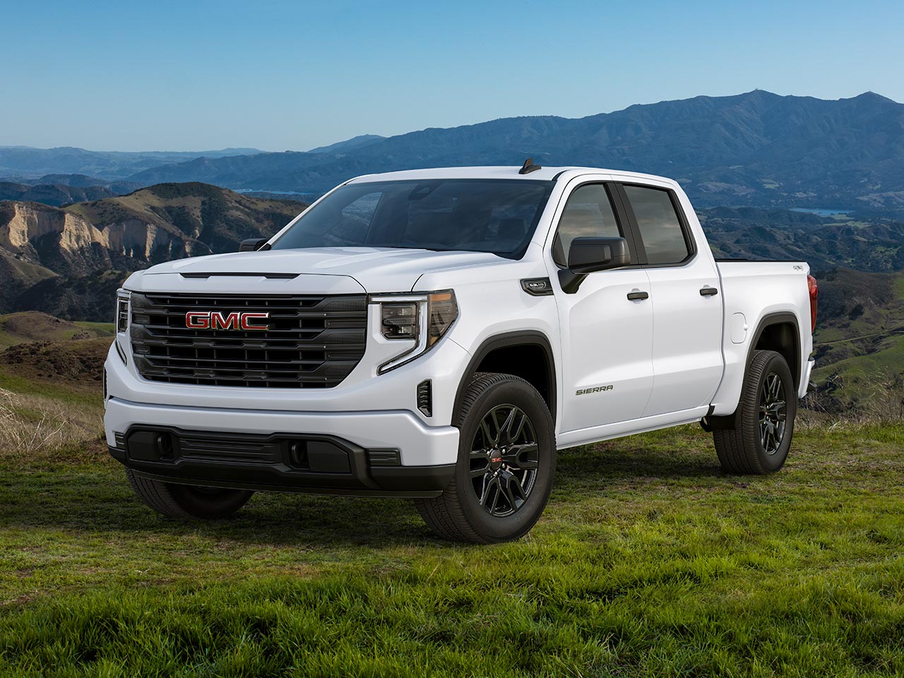 Front Three-Quarters View of a White 2026 GMC Sierra 1500 Pro parked in a Green Valley.