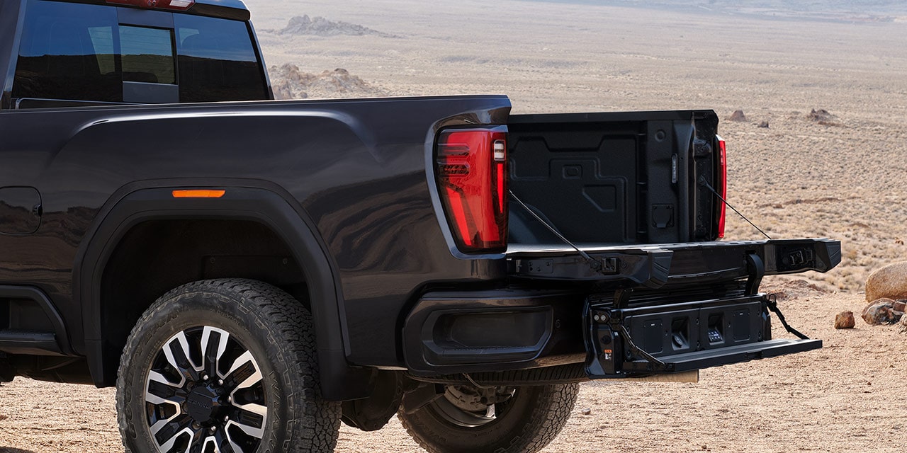 Close-up View of the MultiPro Tailgate with Step Lowered on a 2026 GMC Sierra HD Denali Luxury Truck.