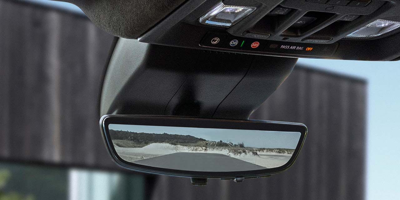 Close-up of the Rear View Mirror and OnStar Basics In-Vehicle Blue Button inside a 2026 GMC Sierra HD Denali.