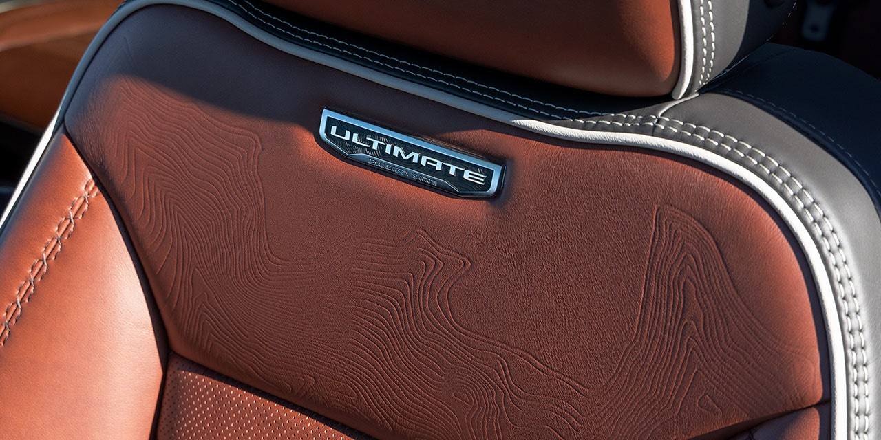 Close-up view of the Premium Materials and Ultimate Trim Nameplate on the seat of the 2026 GMC Sierra HD Denali.