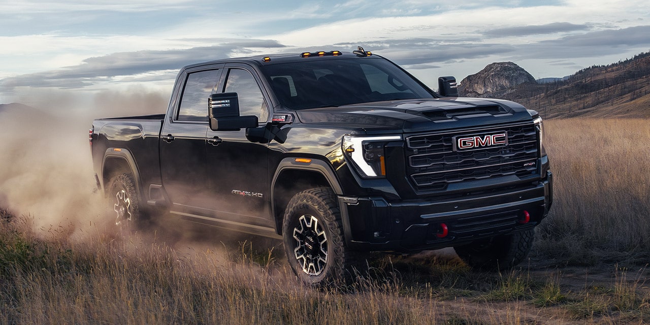 The 2026 GMC Sierra HD Pro Truck Driving Off-Road and Kicking up Dust.