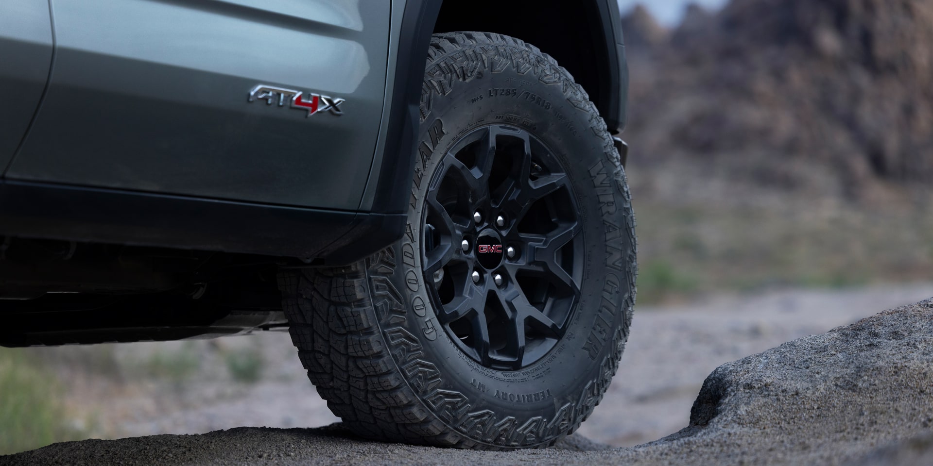 Gros plan sur une roue et un pneu robuste d’un GMC Sierra 1500 AT4X gris