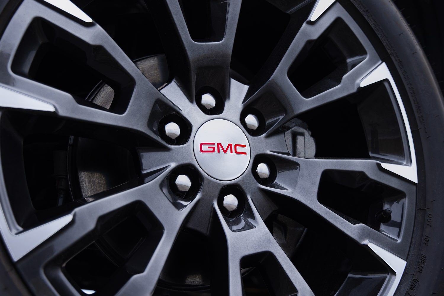 Gros plan sur le capuchon central d’une roue de GMC Sierra 1500 avec logo GMC rouge