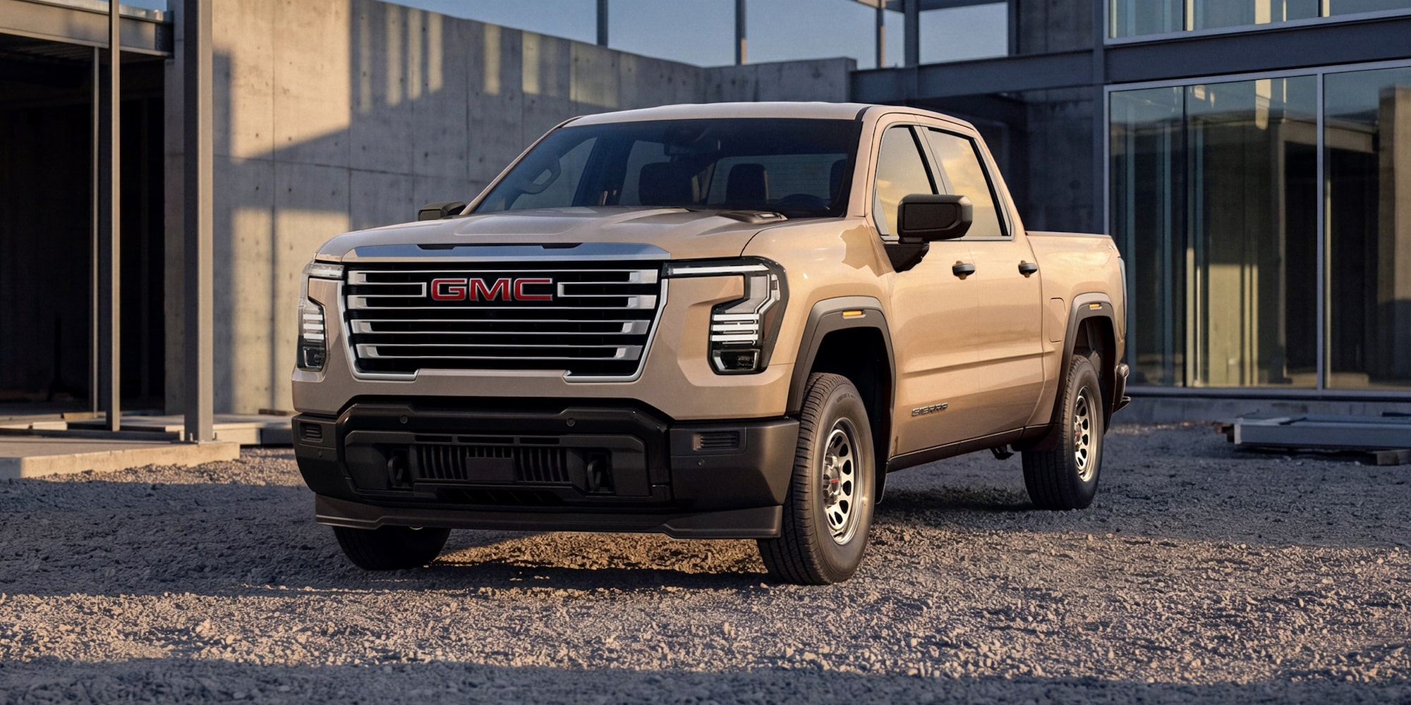 Vue de trois quarts avant d’un GMC Sierra 1500  foncé stationné devant un bâtiment moderne