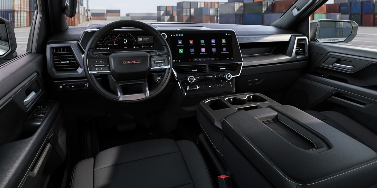 Vue de l’habitacle côté conducteur du GMC Sierra 1500 avec large écran d’infodivertissement et volant
