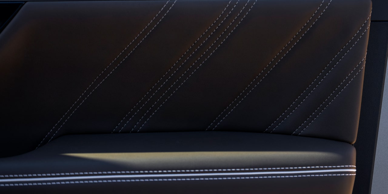 Gros plan sur un panneau de porte en cuir brun foncé du GMC Sierra 1500 avec surpiqûres diagonales