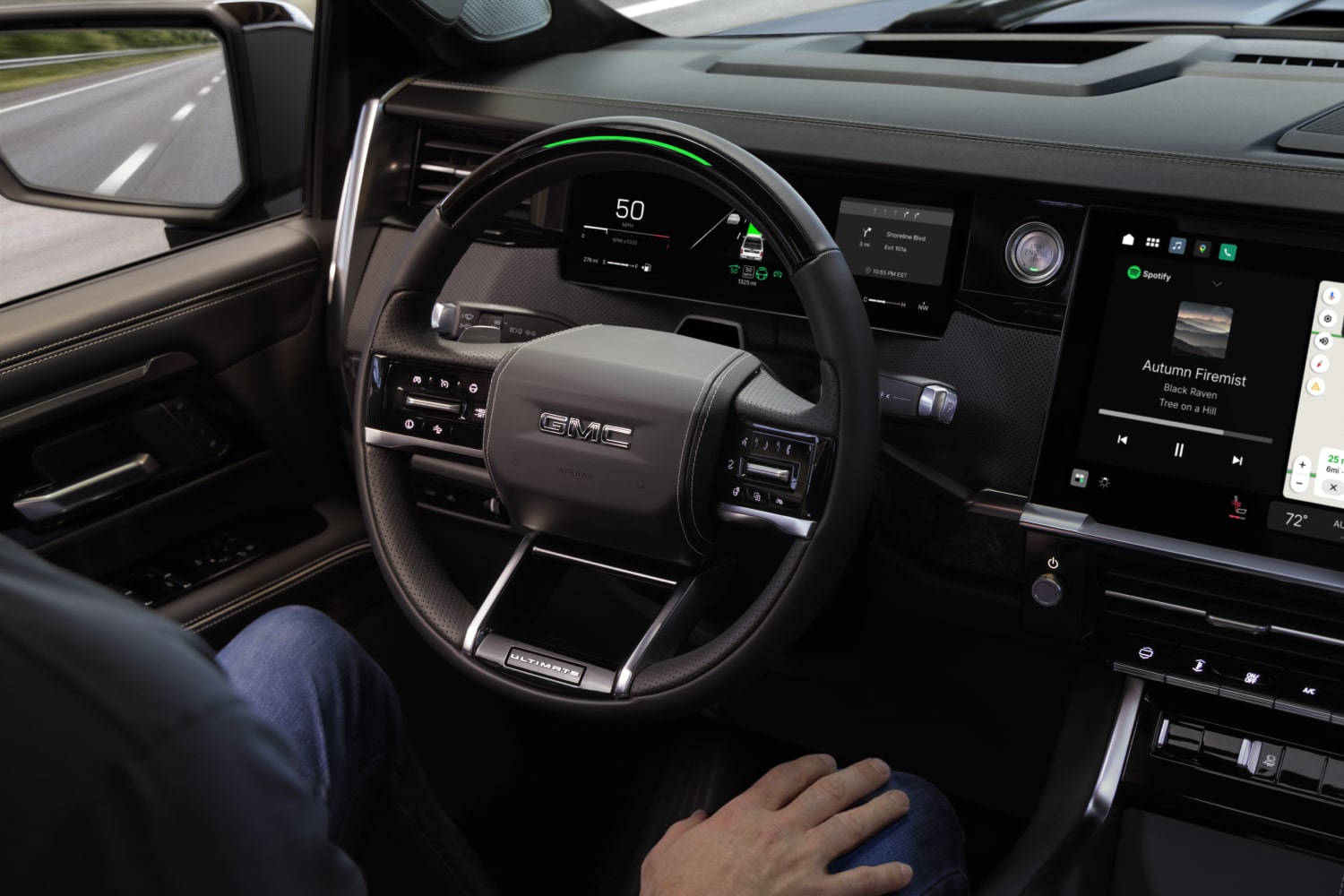 Habitacle d’un GMC Sierra 1500 2027 montrant les mains du conducteur posées sur ses genoux près du volant