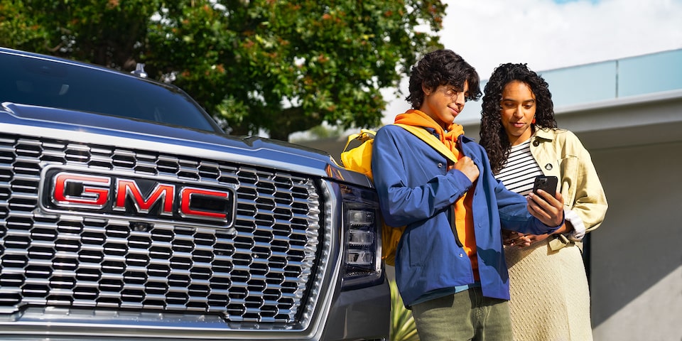 Friends Standing Next to a GMC Sierra 1500 Pickup Truck