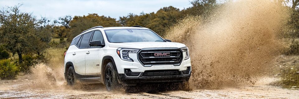 A GMC Terrain AT4 SUV Splashing Up Mud While Off-Roading