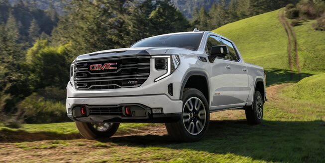 The Summit White GMC Sierra Parked in a Grass Field
