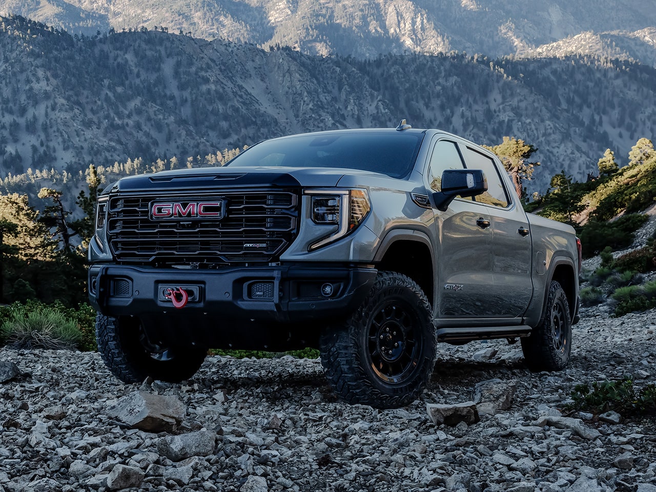 The 2026 GMC Sierra AT4 Off-Road Truck Parked on Rocky Terrain  with Mountains in the Distance