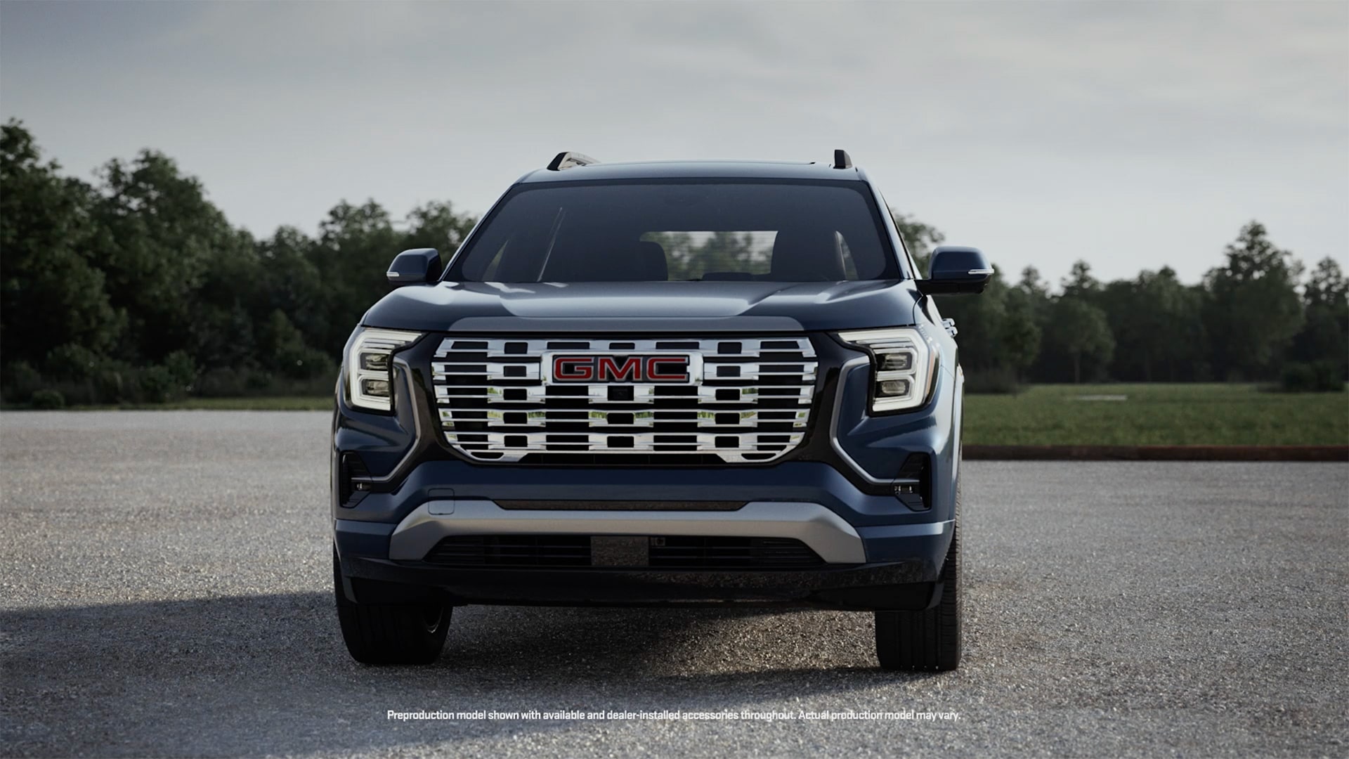 Une vue de face d’un SUV GMC Terrain bleu foncé 2027 avec le logo GMC Terrain 2027 sur la calandre, avec une superposition de bouton Play.
