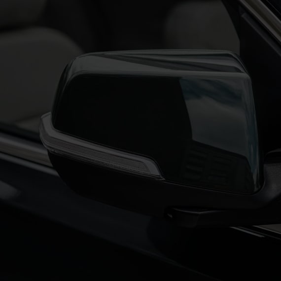 Close up view of the exterior side mirror of the 2025 GMC Acadia.