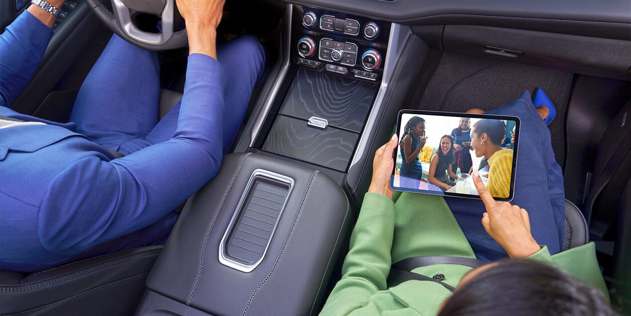 Over-Head View of a Man Driving and a Woman Using an iPad in the Passenger Seat