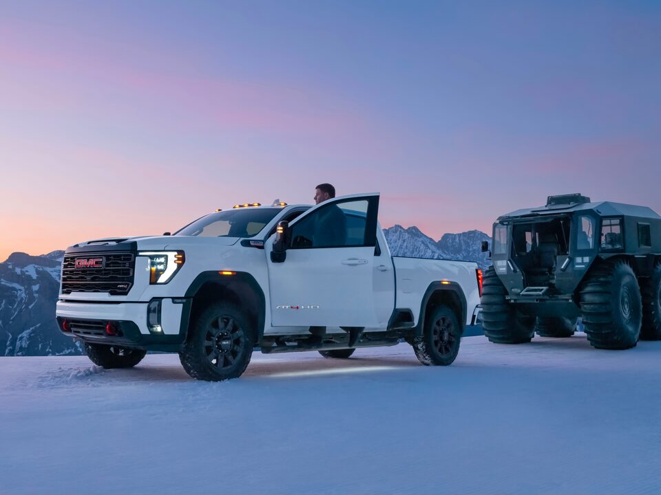 A Man Getting Out of His GMC Truck to Watch the Sunrise Over a Snowy Mountain